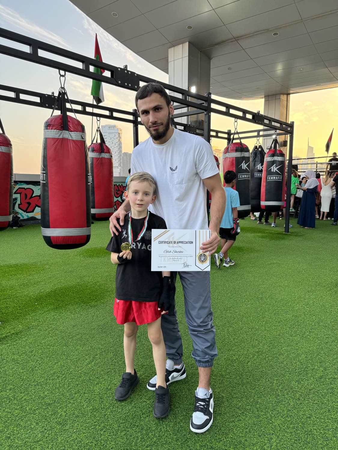 Young student with medal and certificate of appreciation next to Illias